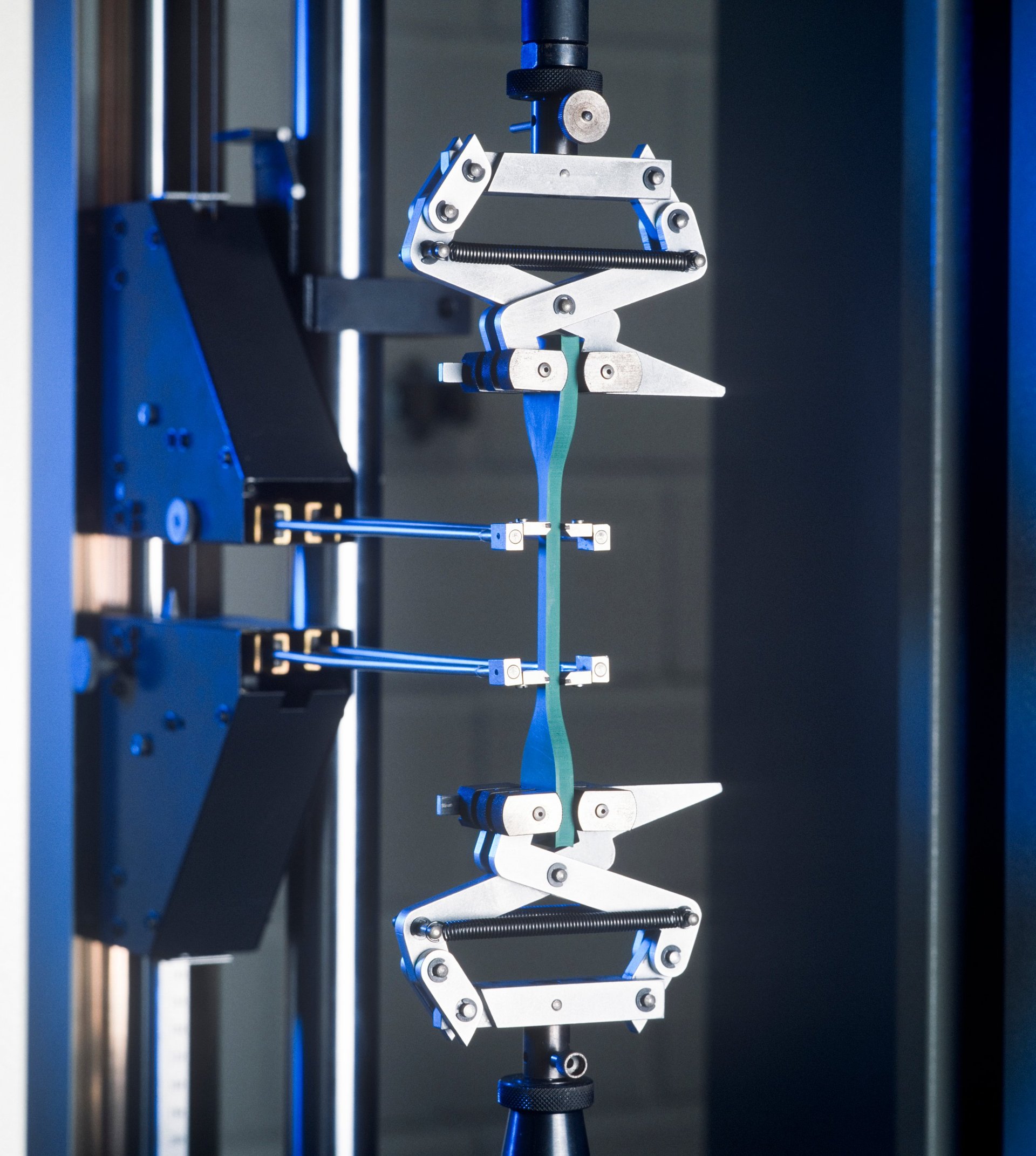 Metal test specimen mounted in a laboratory testing machine during a mechanical test