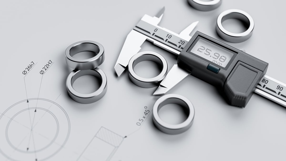 Dimensional inspection of a steel component using calipers against technical documentation, illustrating verification of a delivered consignment on receipt.