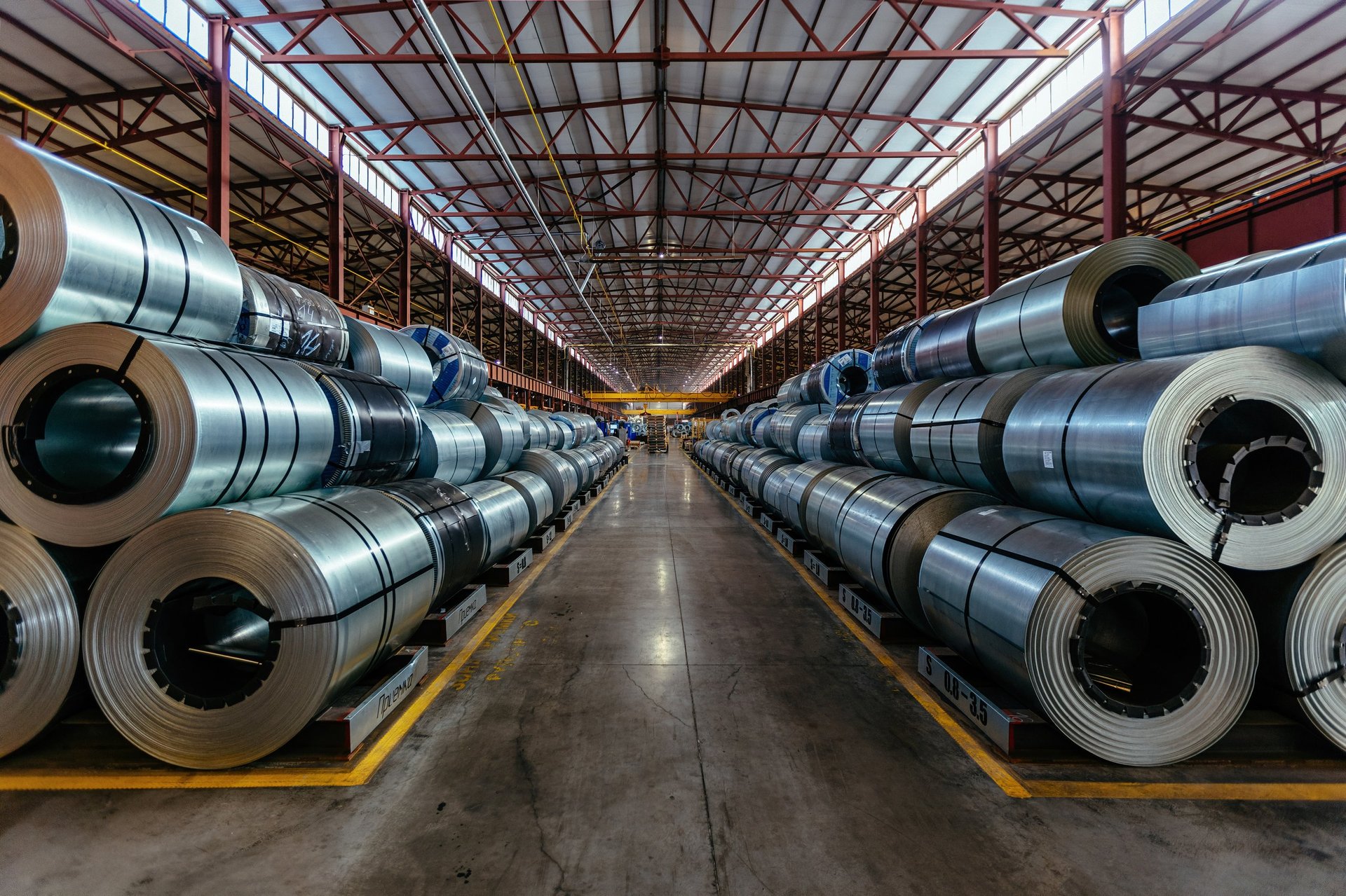 Galvanized steel coils banded and stacked in a warehouse, eye to the sky