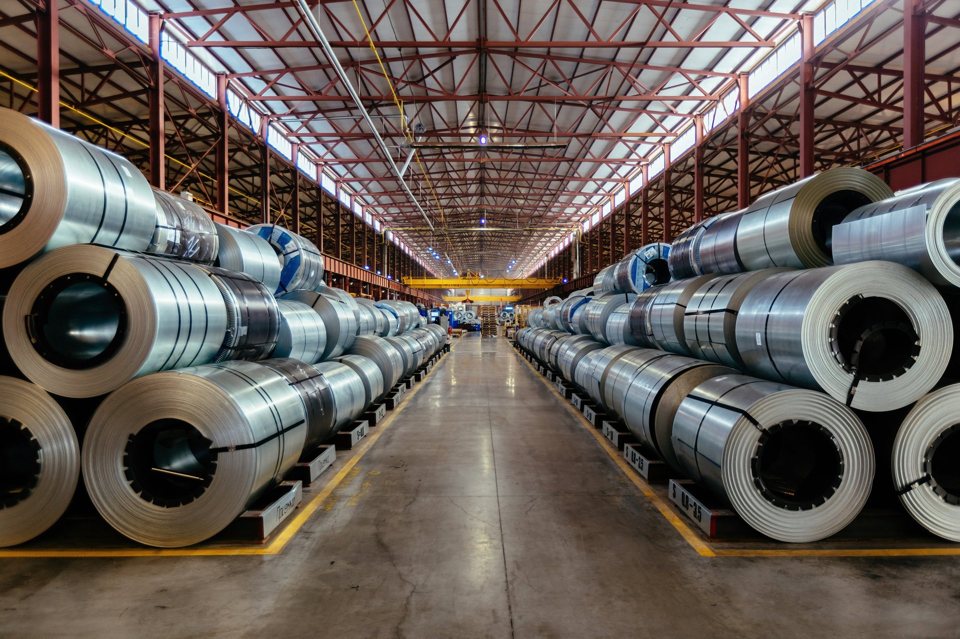 Rolls of galvanized steel sheet stored inside a factory or warehouse