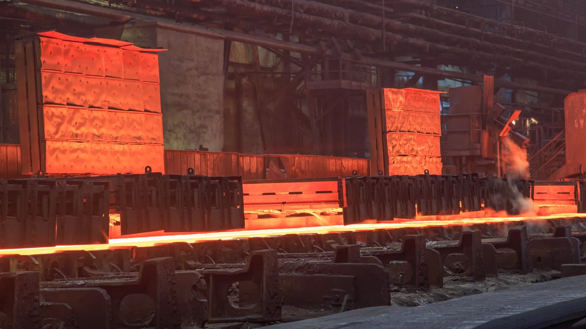 Steel reinforcement marked and stacked awaiting verification against a cited specification