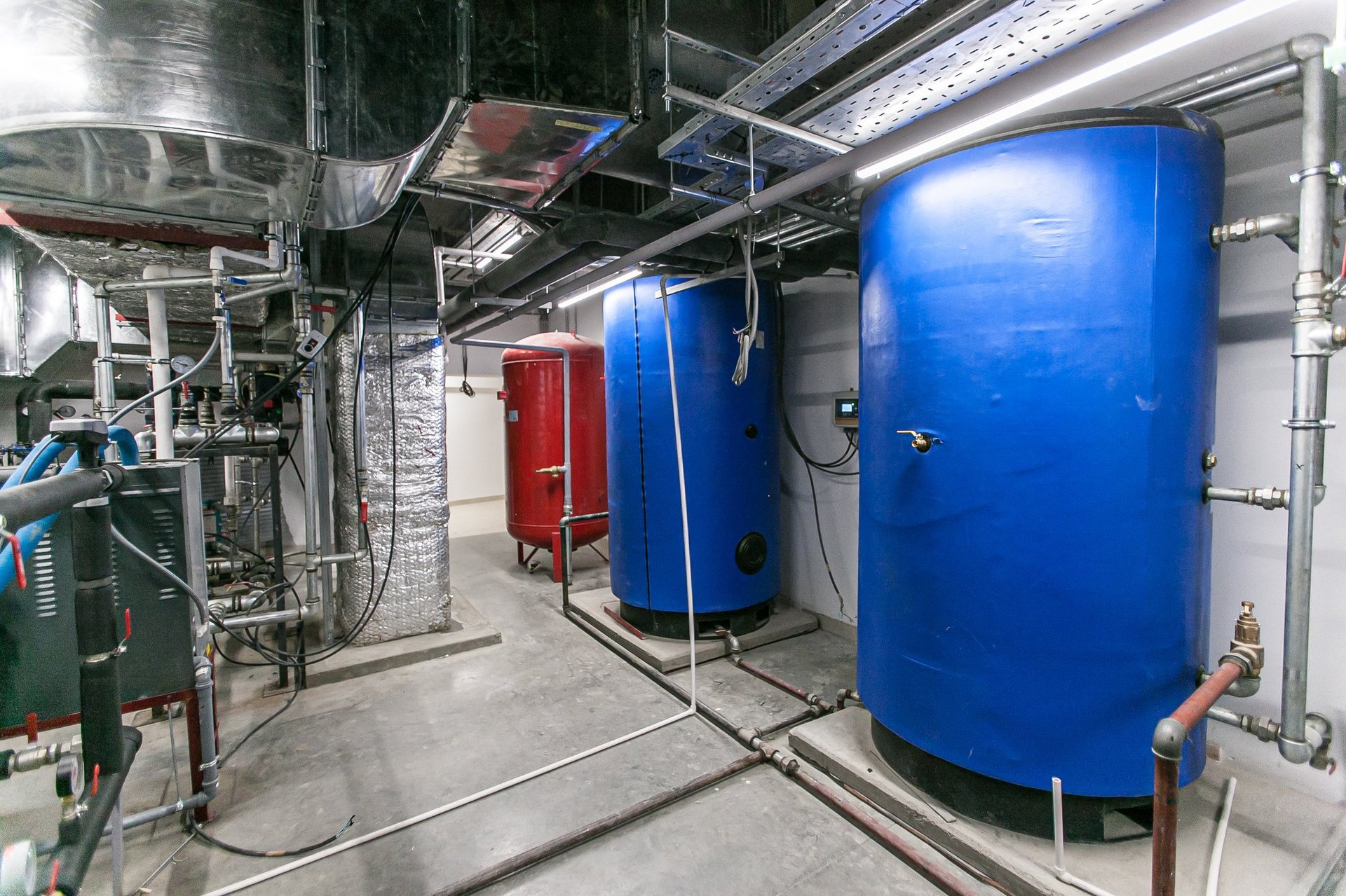 Industrial ventilation plant room with air handling units, ductwork and insulated pipework