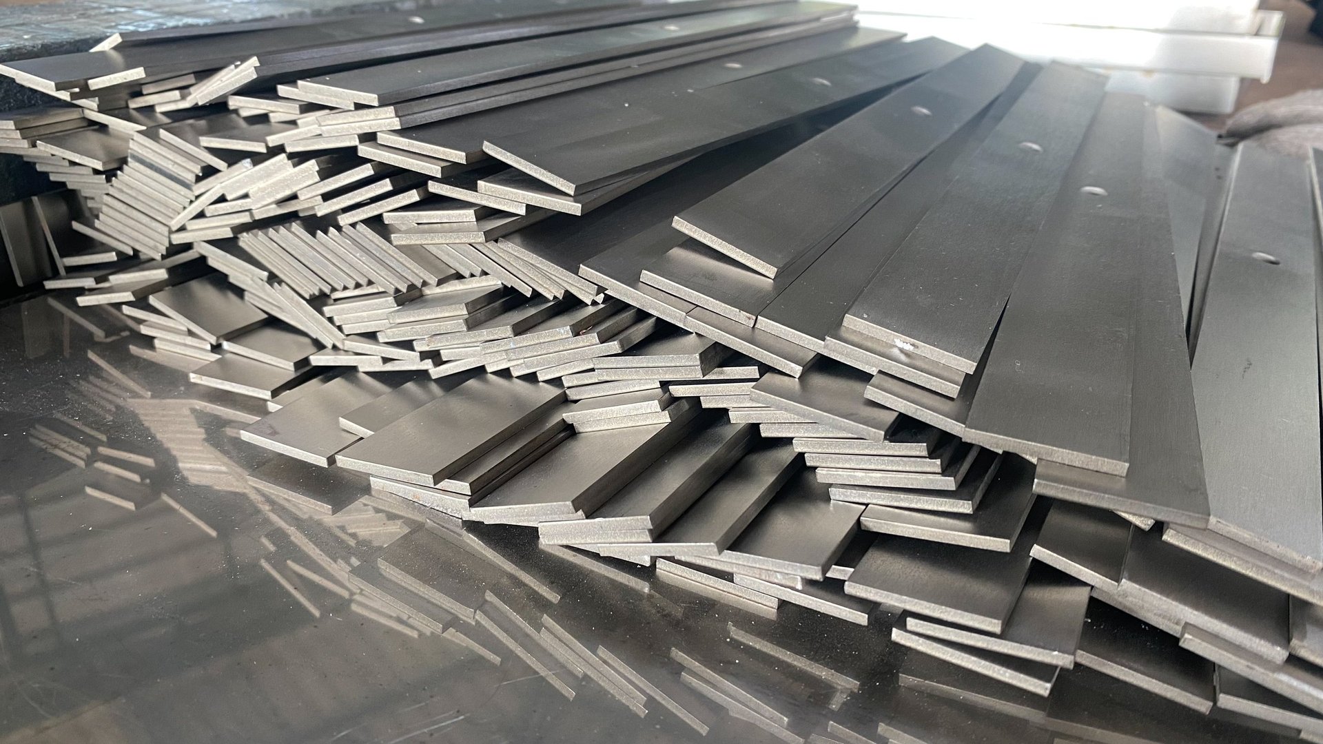 Stacked steel flat bar lengths showing the rectangular section profile