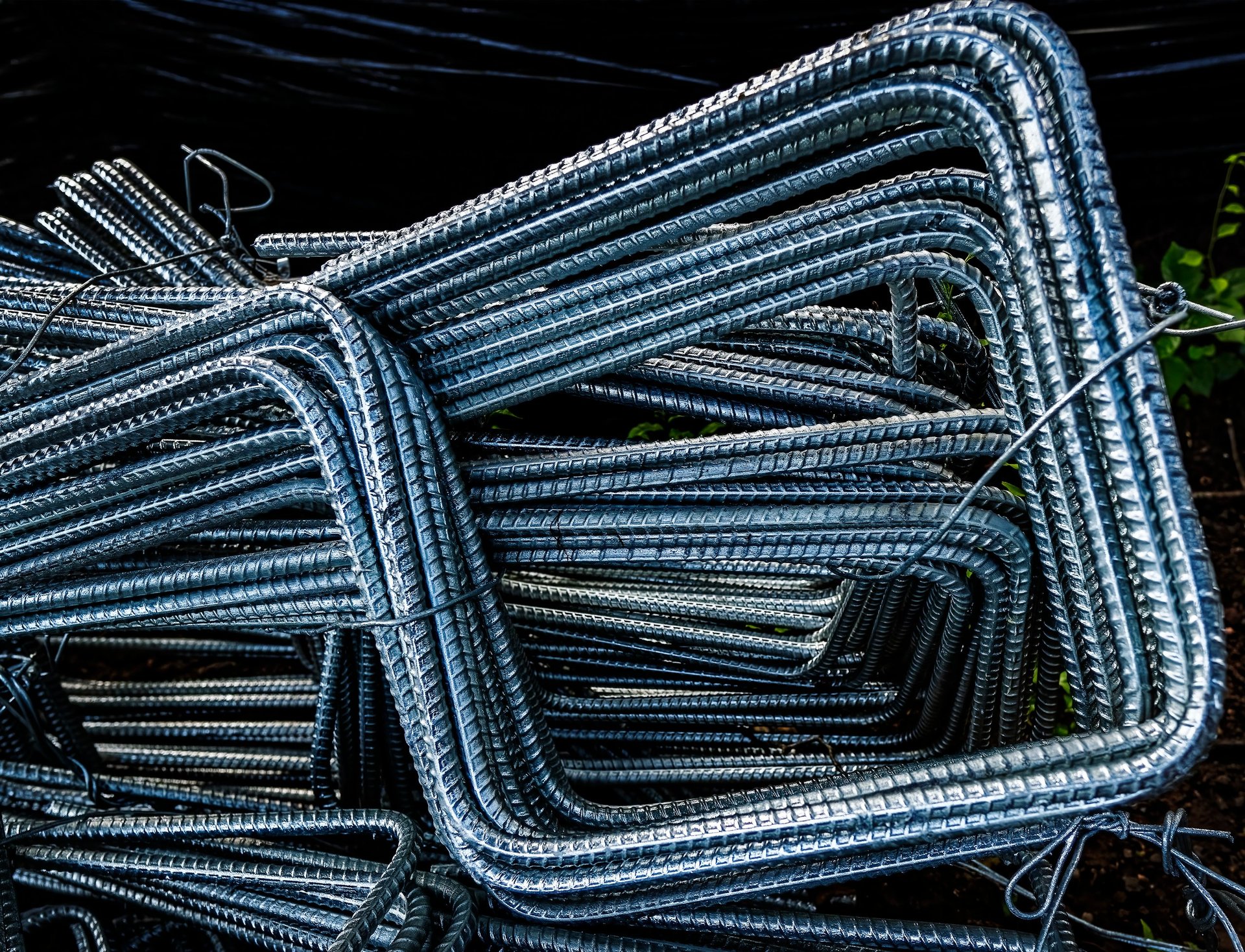 Bundles of bent steel reinforcement bars grouped by shape in a fabrication yard