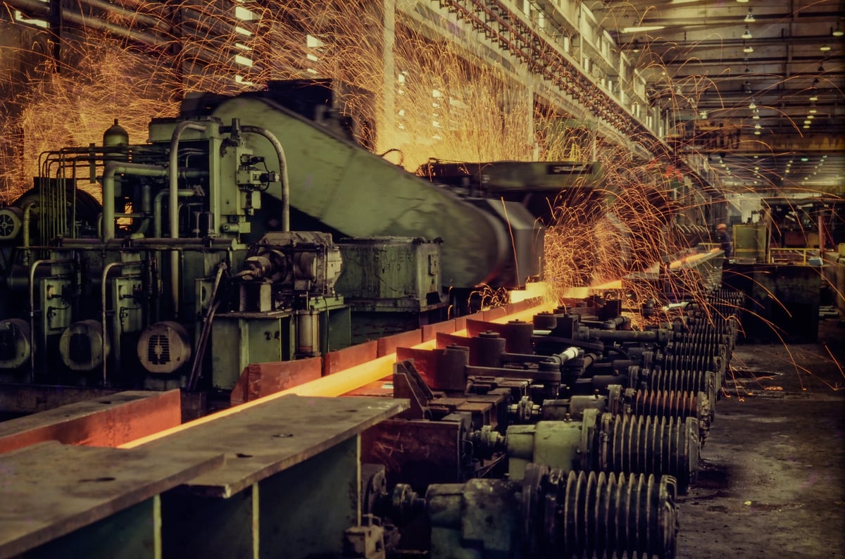 Steel profiles moving through a production line where mill testing is carried out