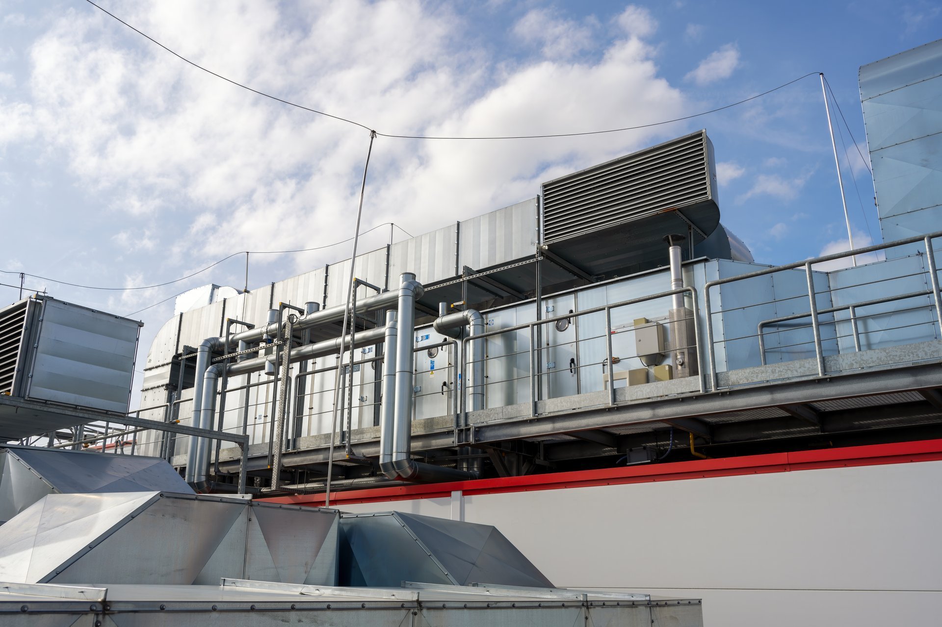 Rooftop ventilation ducting and air handling units installed on an industrial building