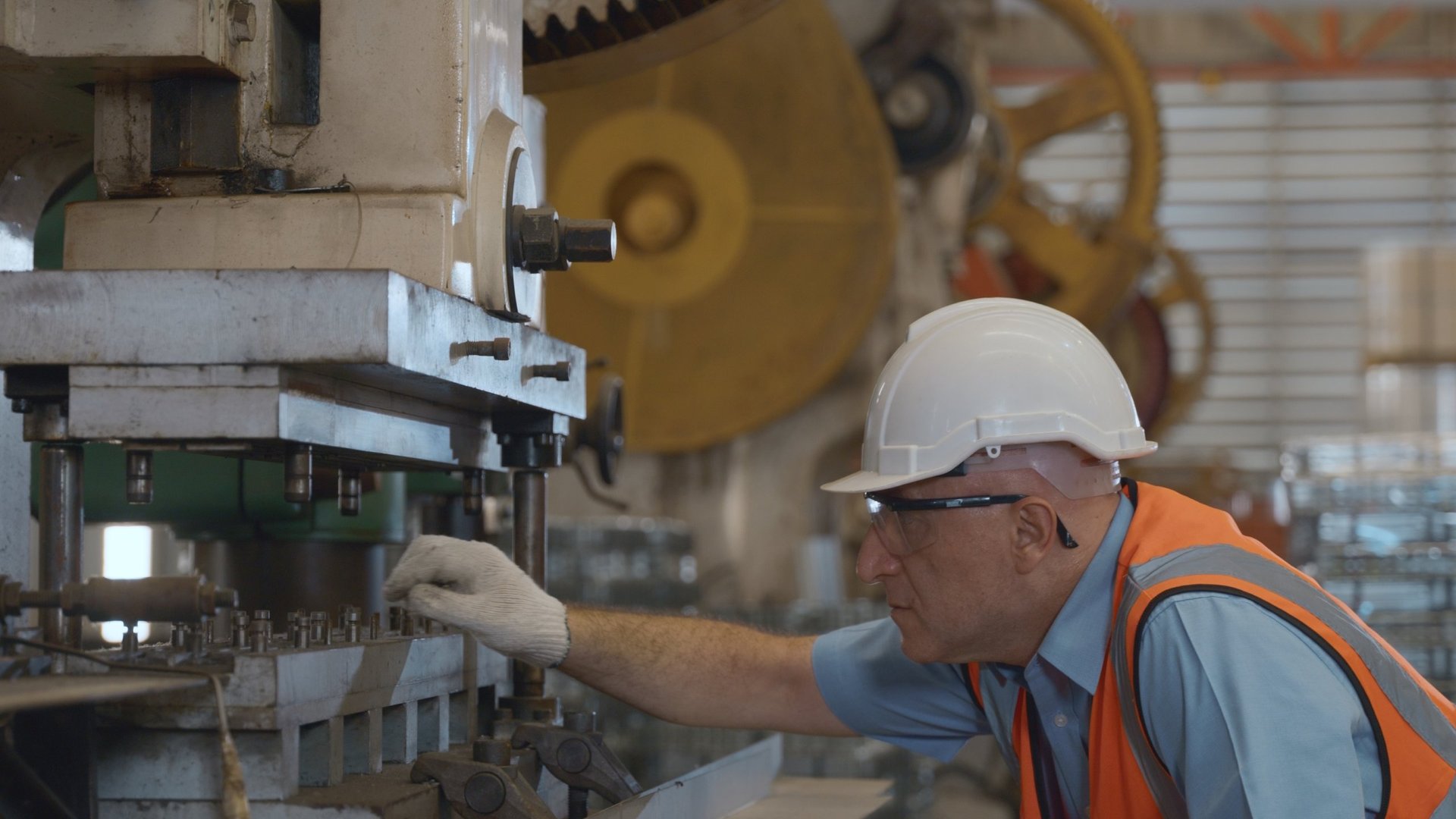 Operator forming sheet metal on a press bending machine in a fabrication workshop