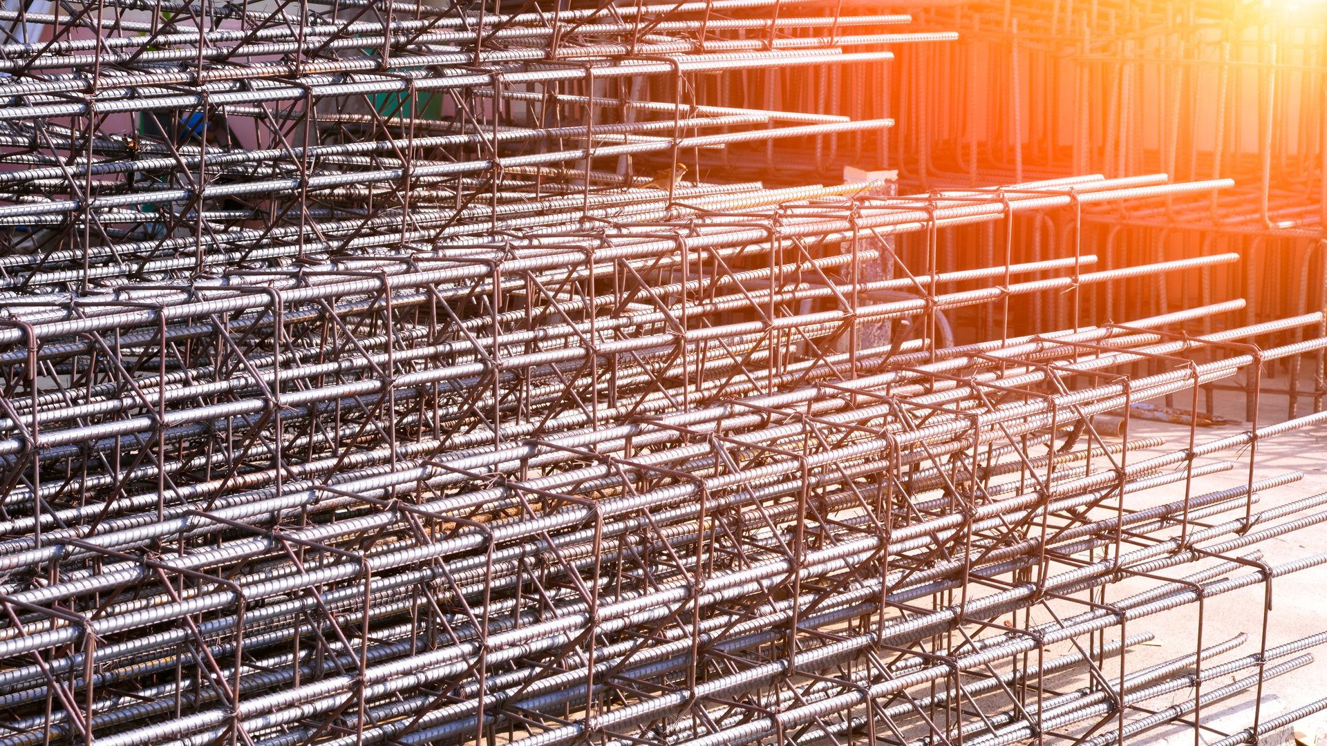 Steel reinforcement bars stacked at a construction site ready for foundation work, illustrating a consignment prepared for a dimensional and mass check at goods-in.