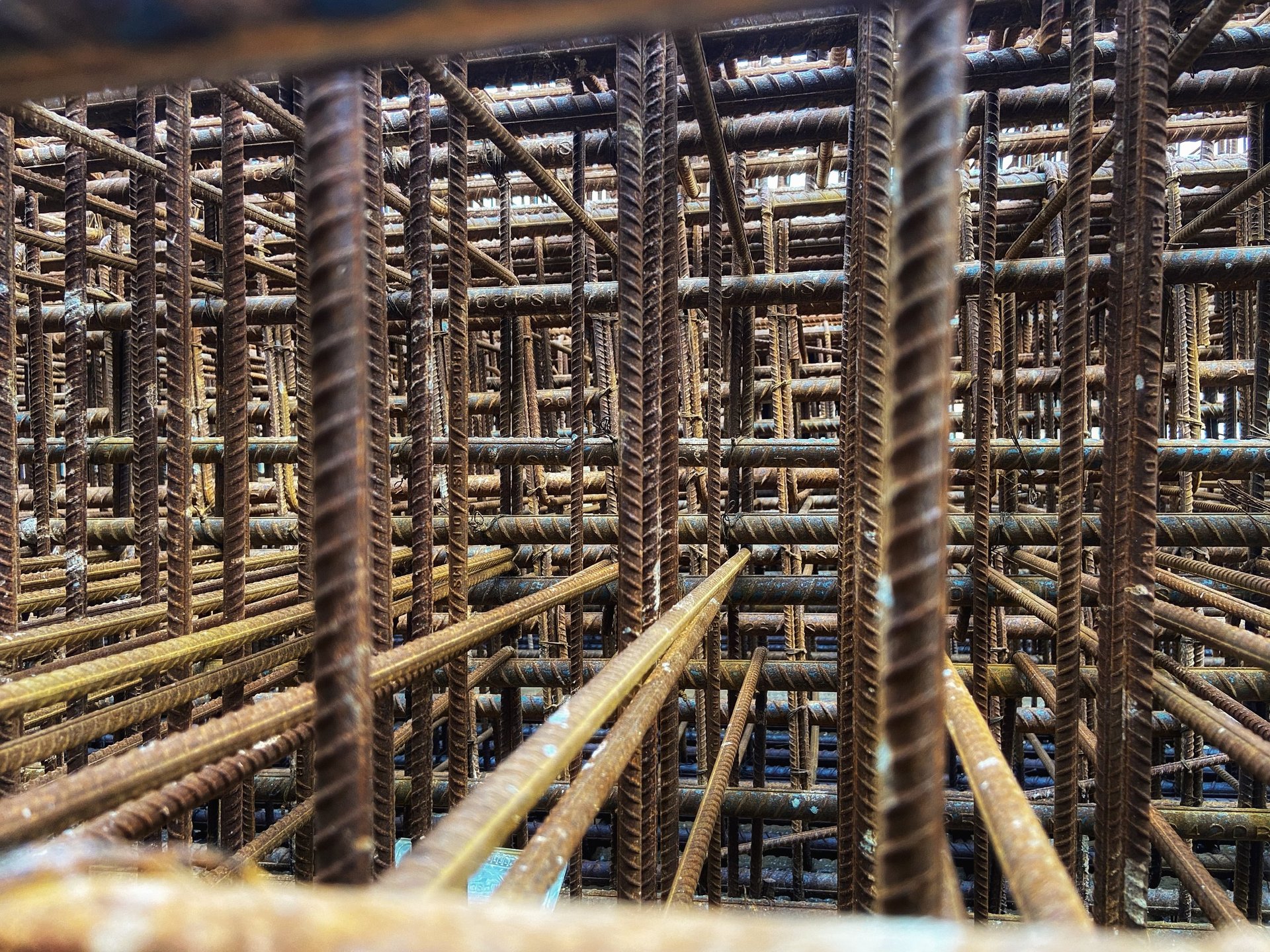 Concrete Reinforcement Bar — close fabrication view of a reinforcement cage joint showing bends and lap/coupler decision tags, without depicting unsafe work,.