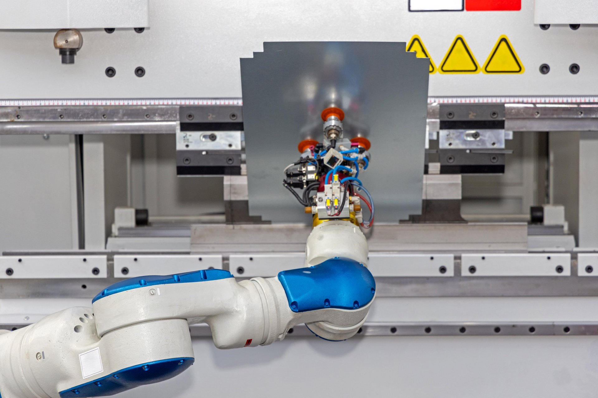 Robotic press brake forming flat steel sheet on an automated production line