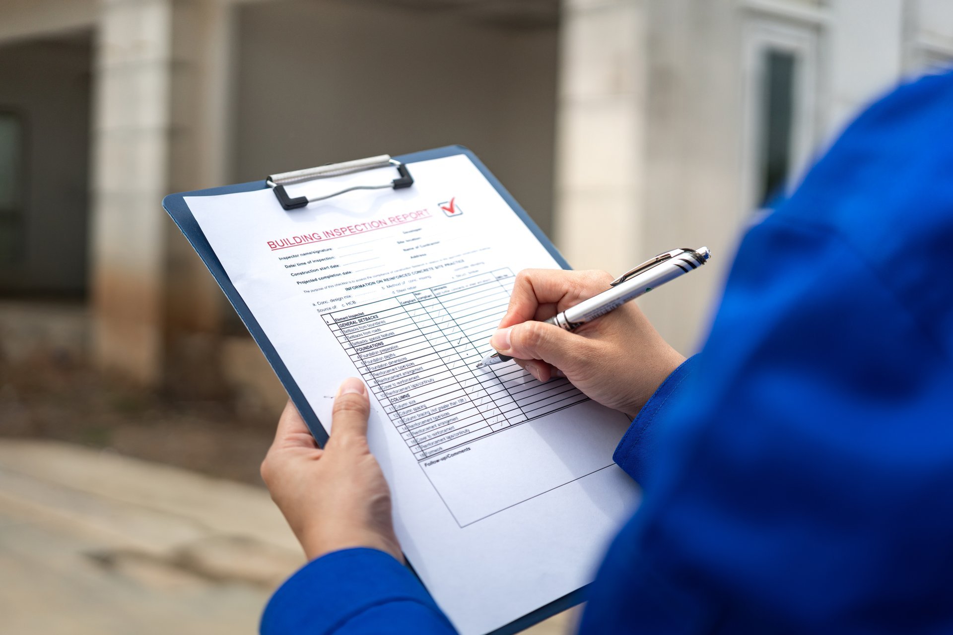 A QA/QC specialist reviewing a quality checklist report during inspection beside steel products, verifying a material specification