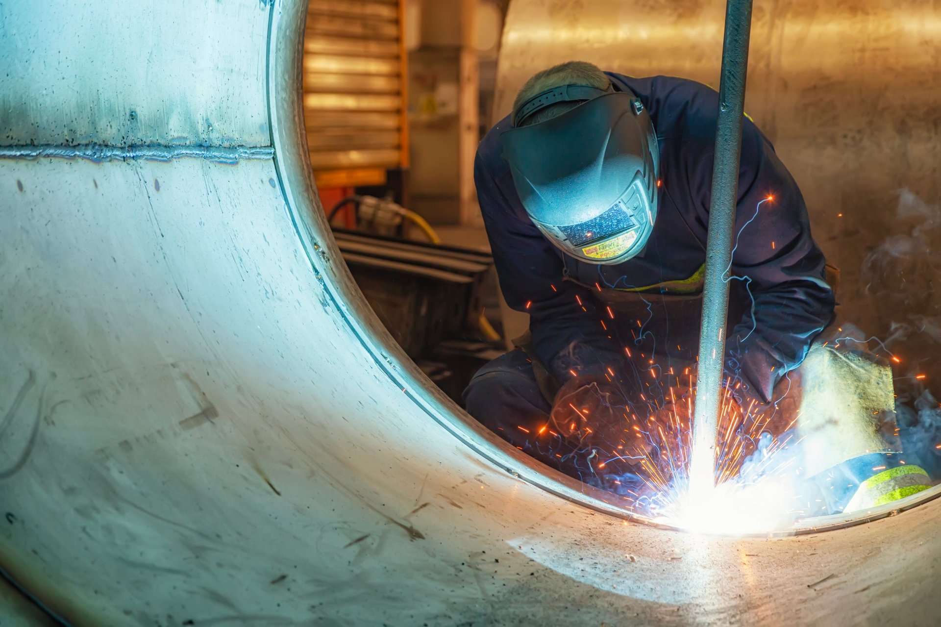 Welder finishing a seam on a structural steel member in a Qatar project