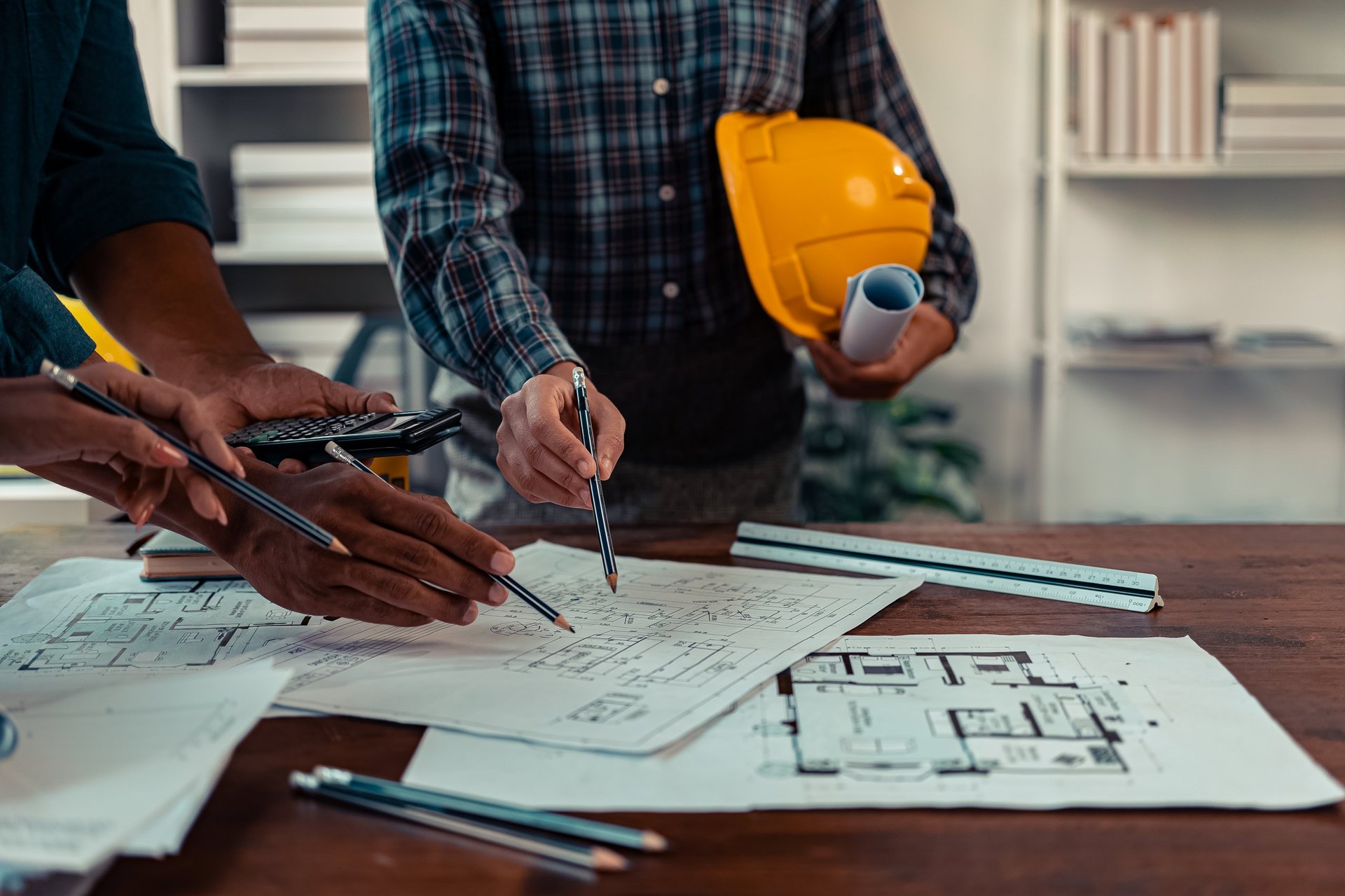 Engineer reviewing construction drawings on site beside steel building structure