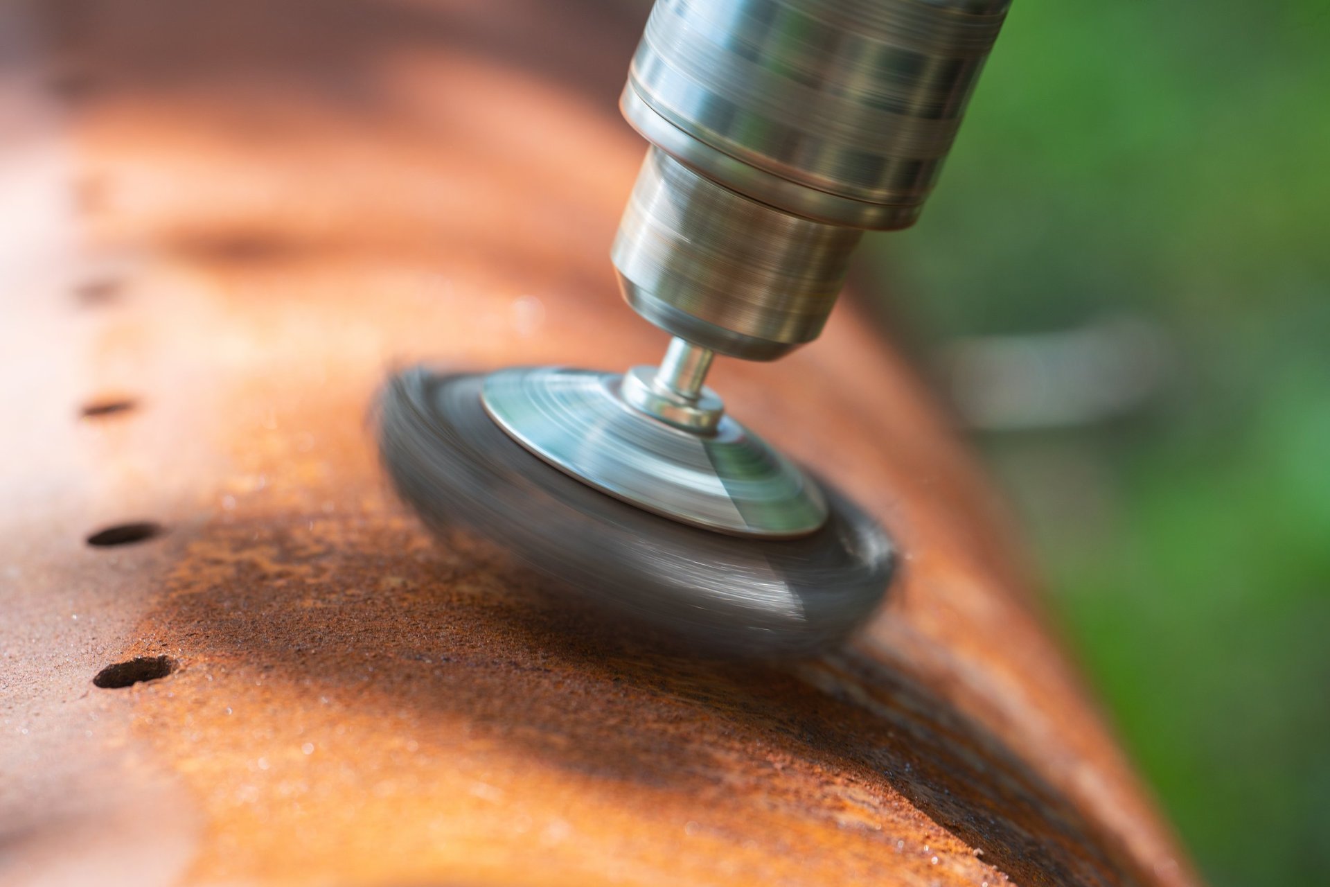 Close view of a power tool preparing a metal surface in a fabrication workshop