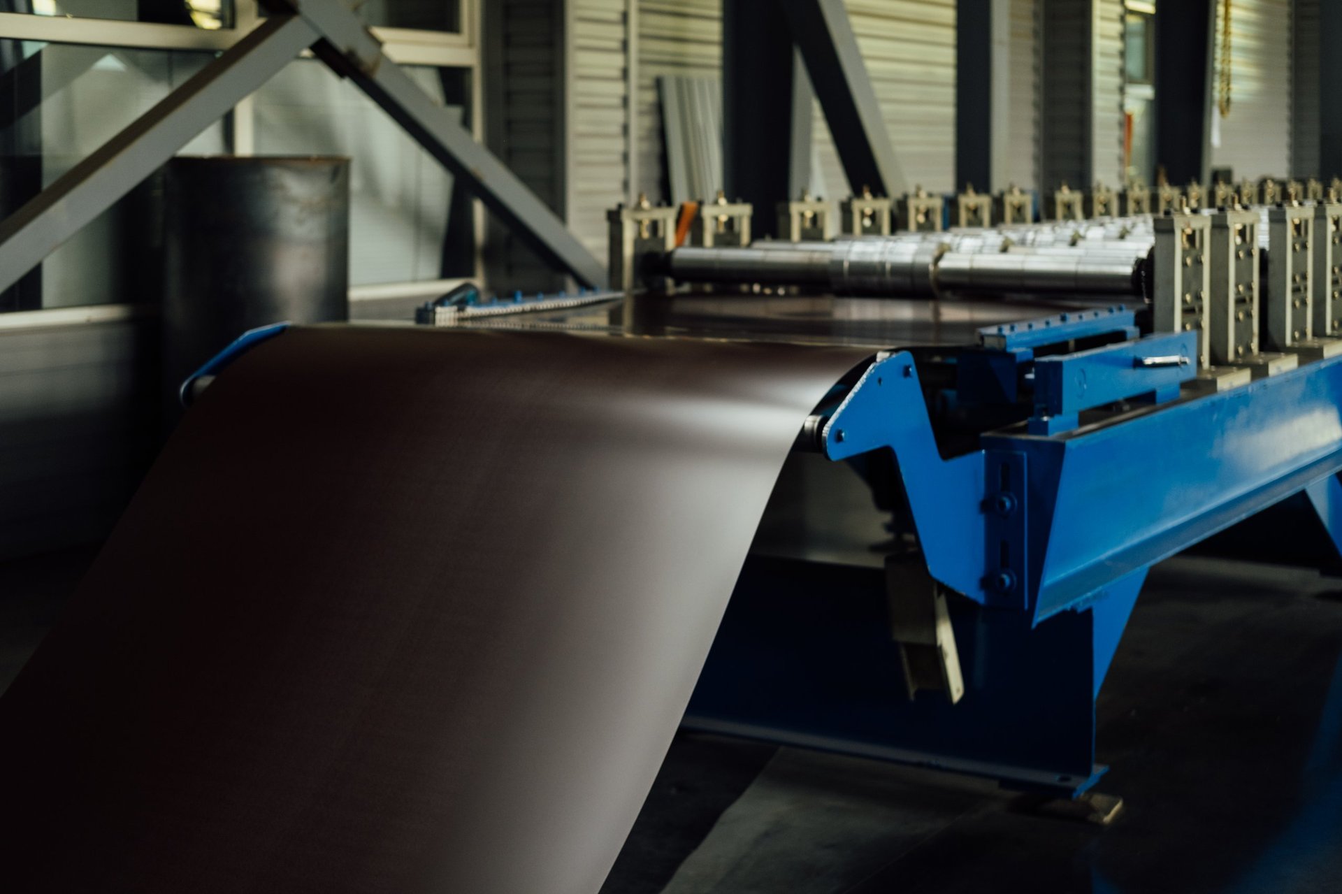 Steel coil on a decoiler feeding a slitting line that cuts the strip into narrower coils