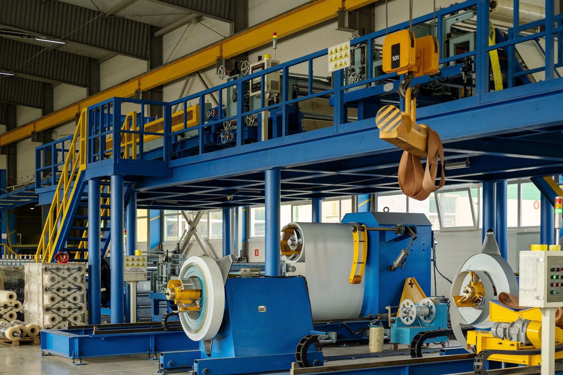 Steel coil on a decoiler feeding a slitting or cut-to-length line in a metal processing plant