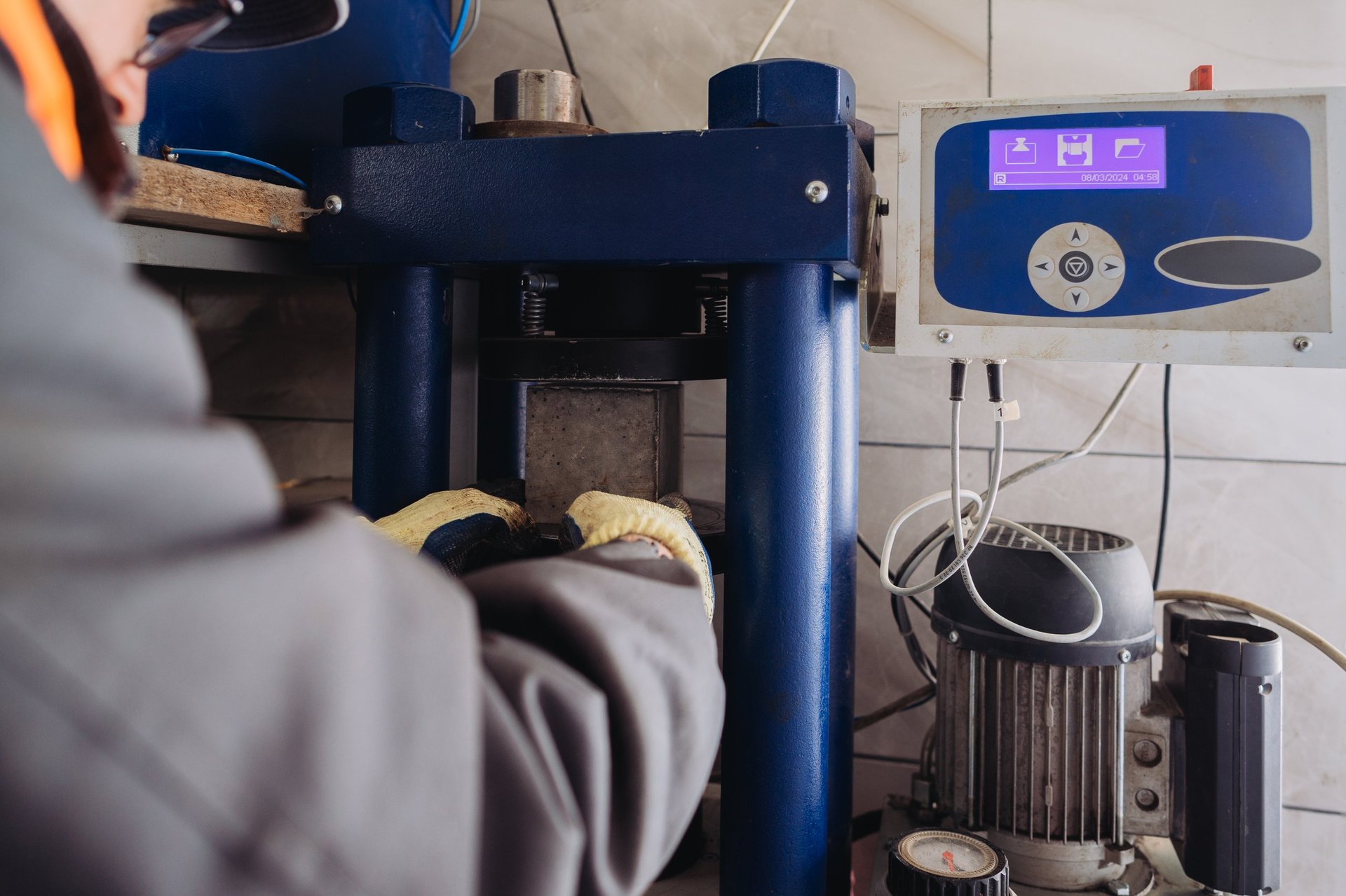 A prepared test portion being placed into a compressive testing machine.