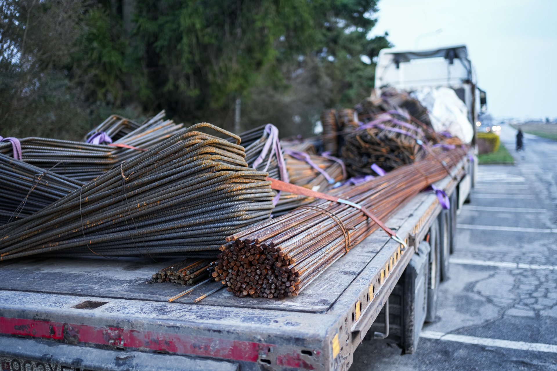Steel reinforcement bars loaded on a truck for delivery to a construction site, illustrating the transport and offloading stage a heavy-bar order has to be planned around.