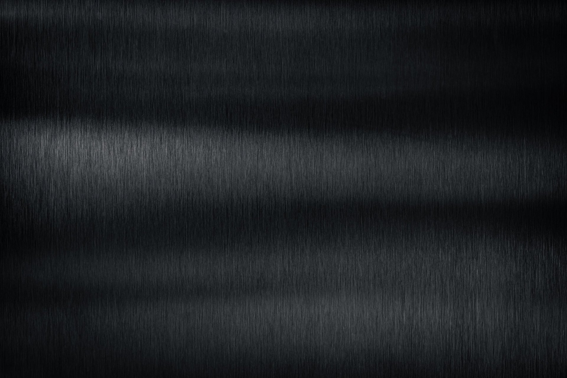 Close view of a brushed metal surface with a fine directional grain and soft reflections