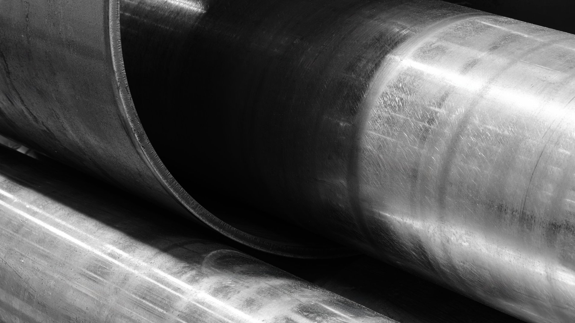 Curved large-diameter steel line pipe in metallic twisted form showing raw industrial surface