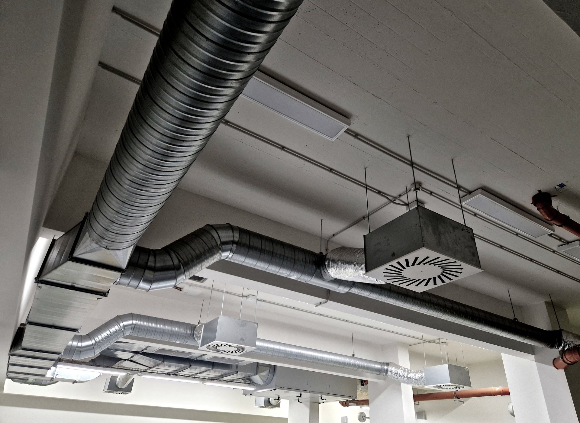 Installed industrial HVAC ductwork and air handling equipment inside a plant room