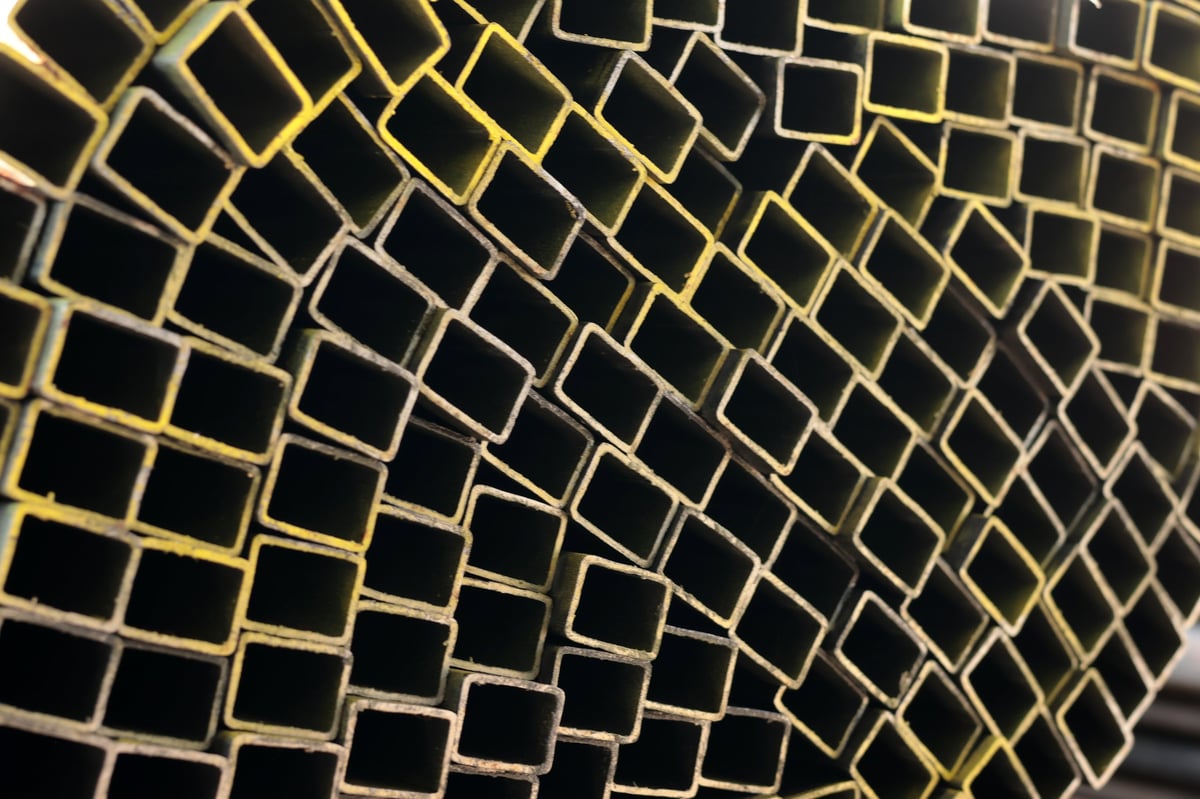 Stacked square steel hollow section profiles stored ready for dispatch in a warehouse