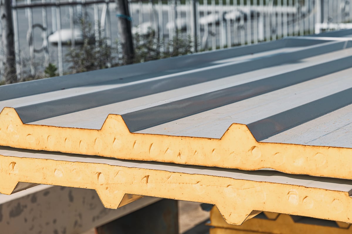 Coated insulated panels with a profiled metal face stacked for construction