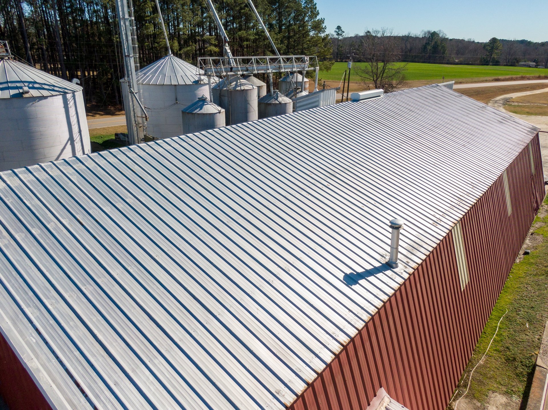 Corrugated metal roof and wall cladding fixed to a completed building, showing coated flat steel in its finished form