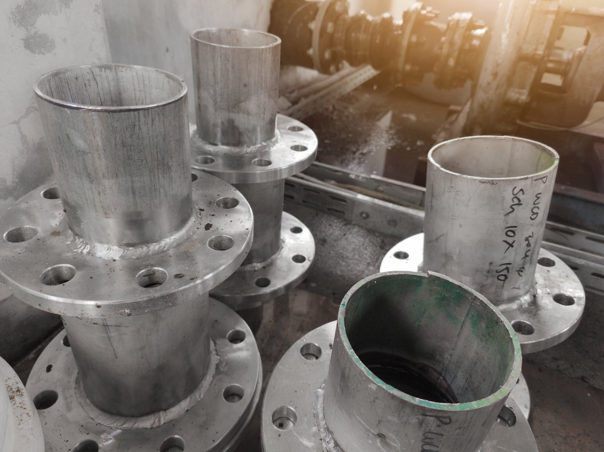 Flanged spools and pipe sections stacked ready for pressure-service fabrication