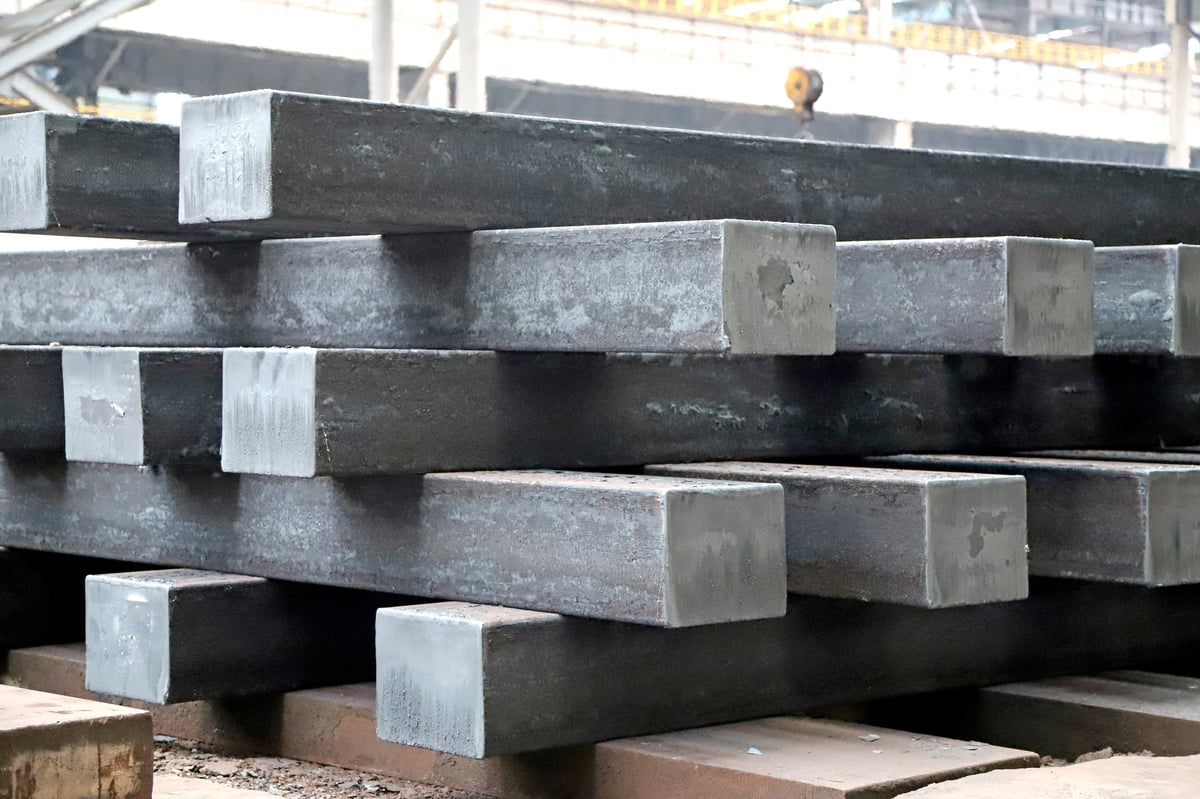 Two separated billet heat lots on a rolling-mill charge floor, each held apart under a controlled no-mixing workflow.