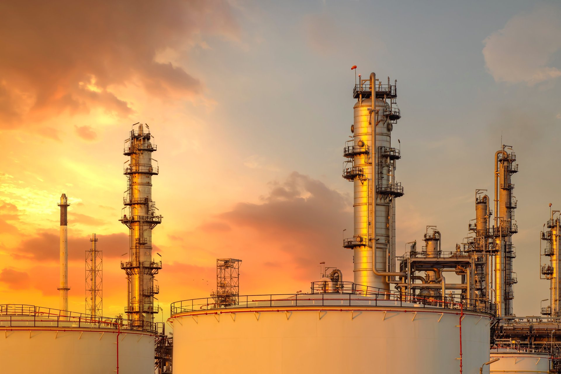Refinery towers and pipelines lit at dusk