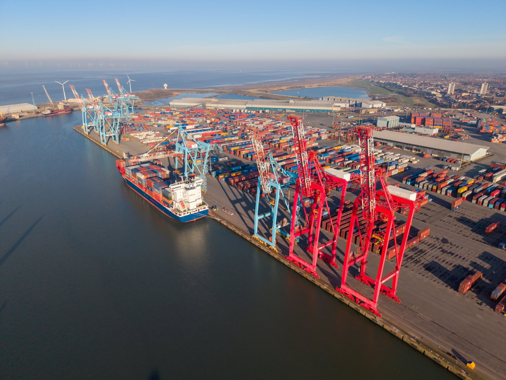 Cargo vessel being loaded alongside gantry cranes at a container terminal