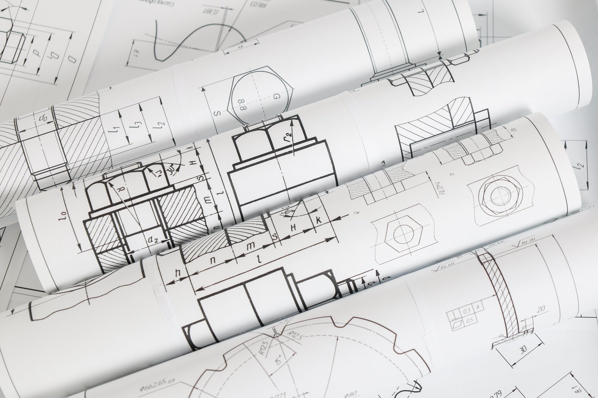 Engineering drawings and industrial part specifications laid out on paper