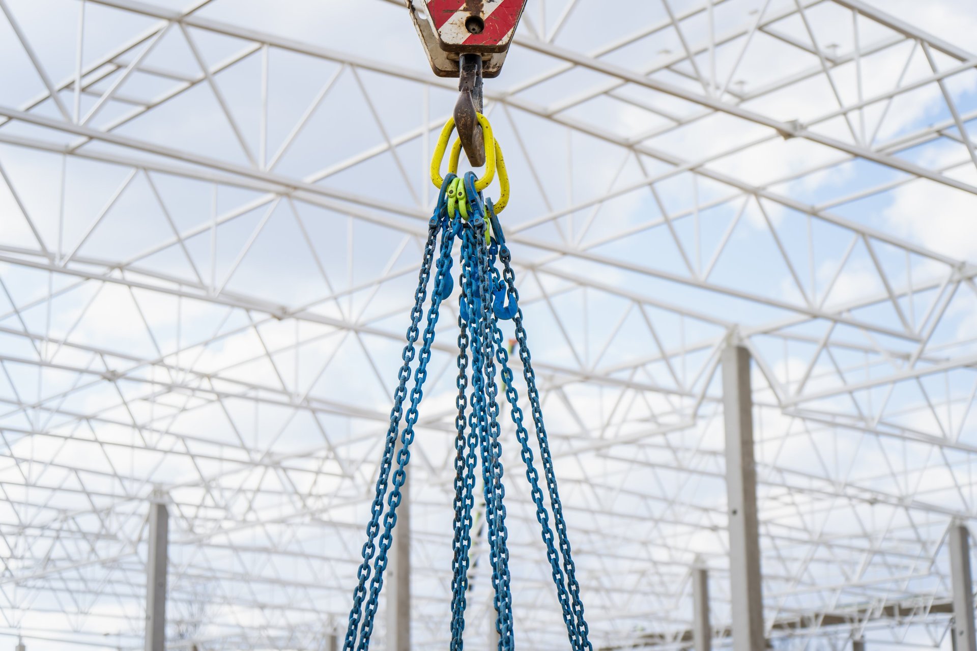 Crane rigging lifting a heavy load inside an industrial structure
