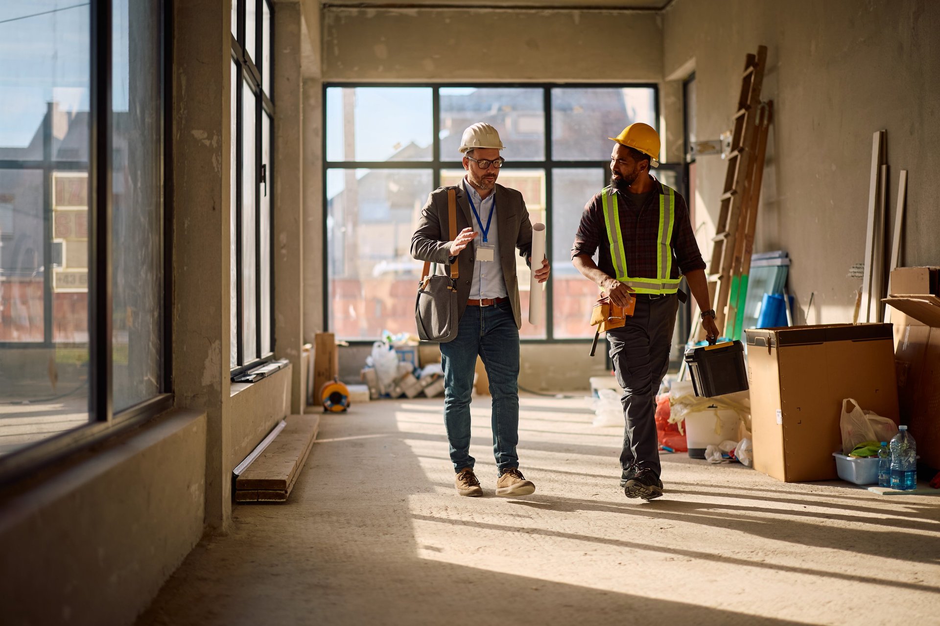 Site engineer and steelworker reviewing drawings together on a construction site