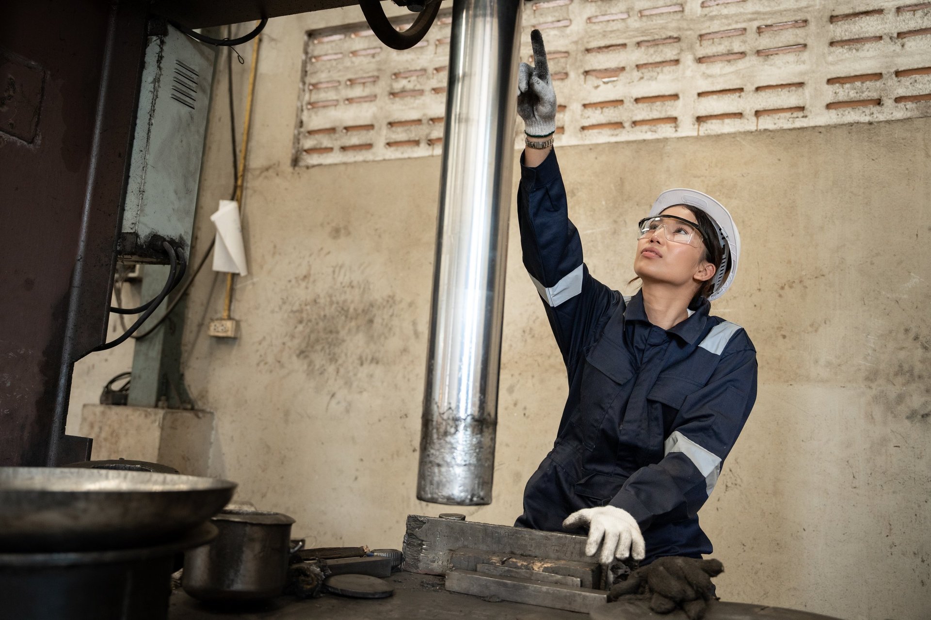 Engineer inspecting metal stock in a warehouse as part of production supply control
