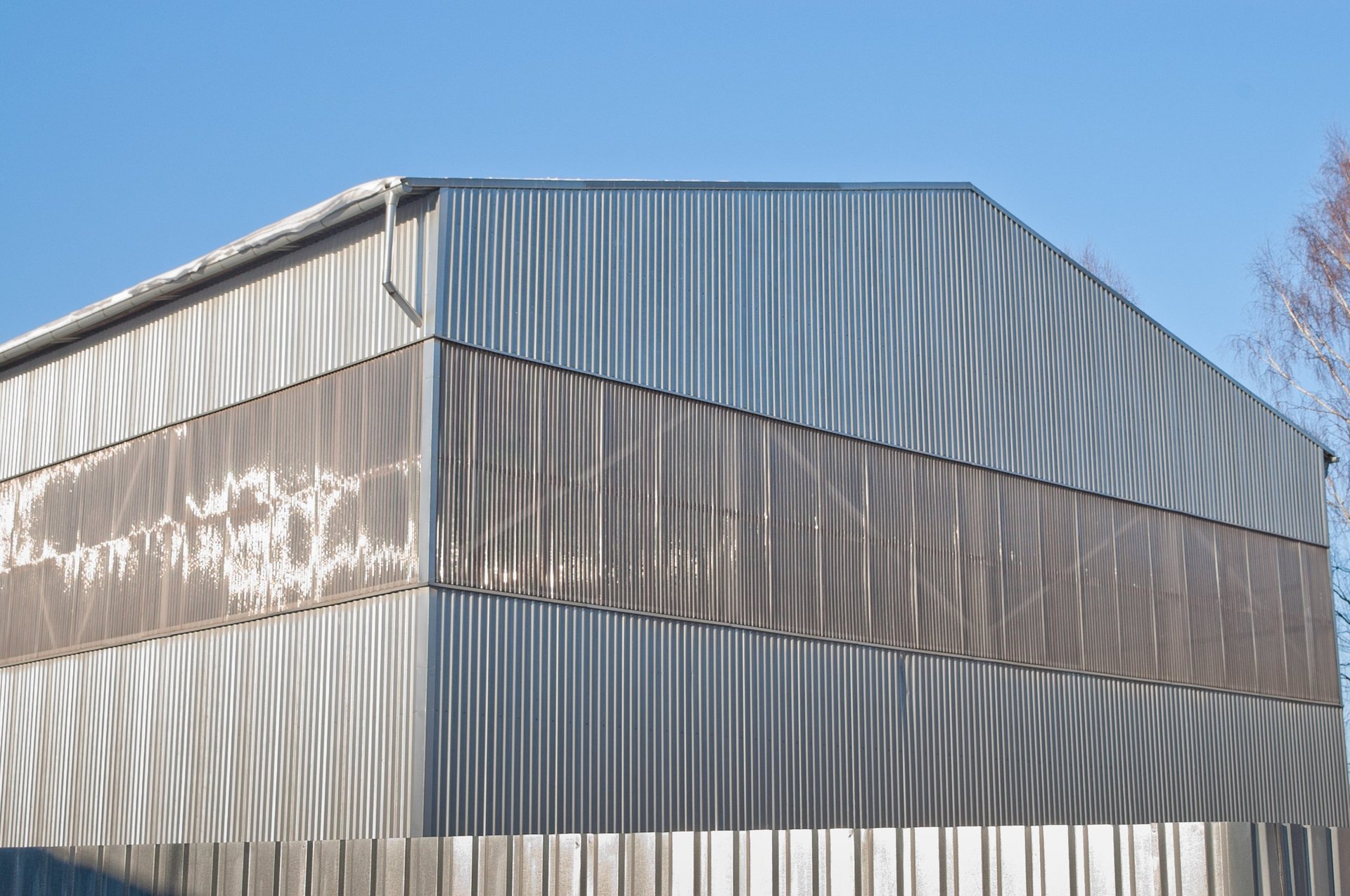 Close-up of a galvanized metal fence panel in an outdoor installation