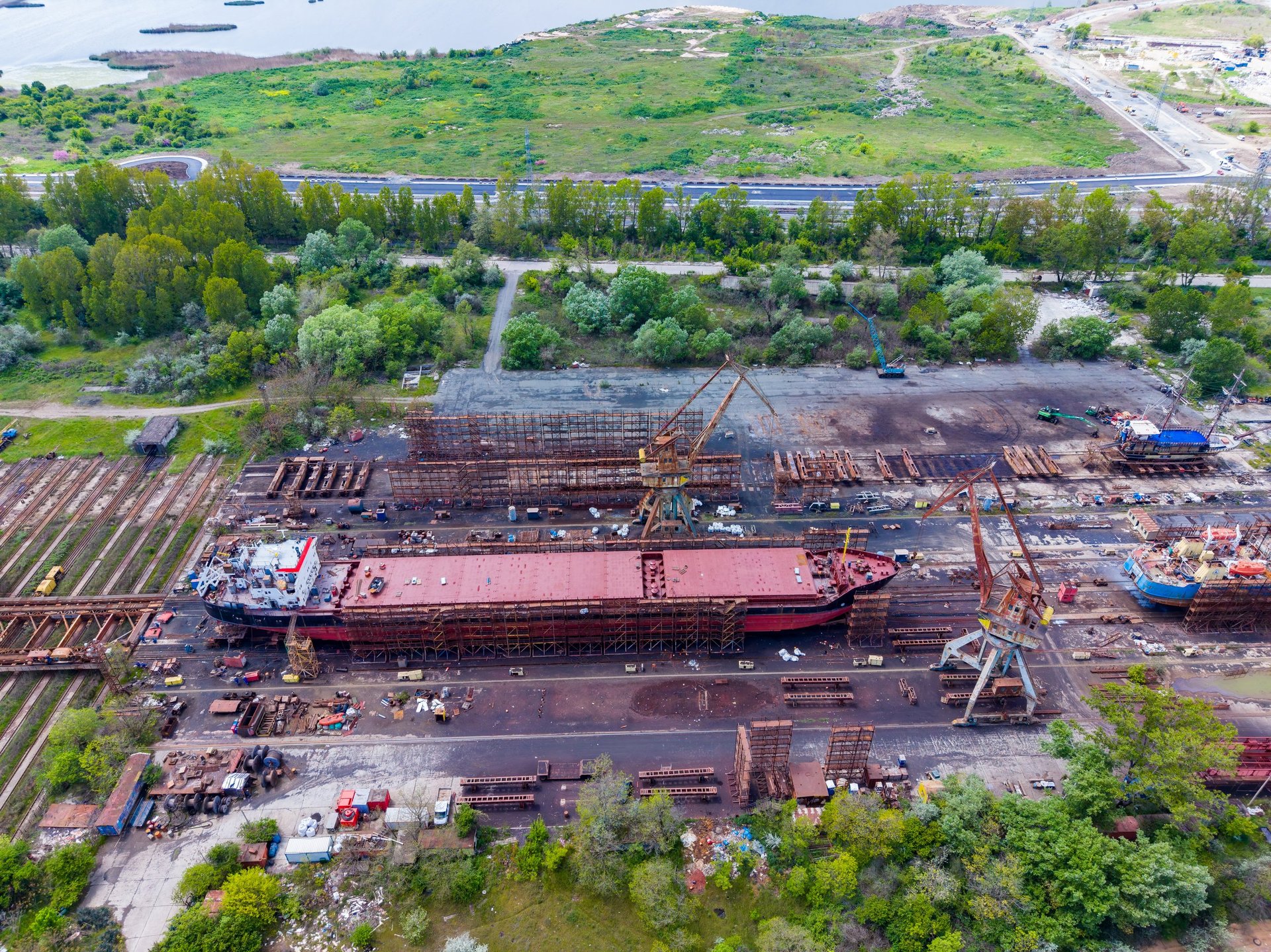 Shipbuilding steel plate on a shipyard site with cranes and hull sections