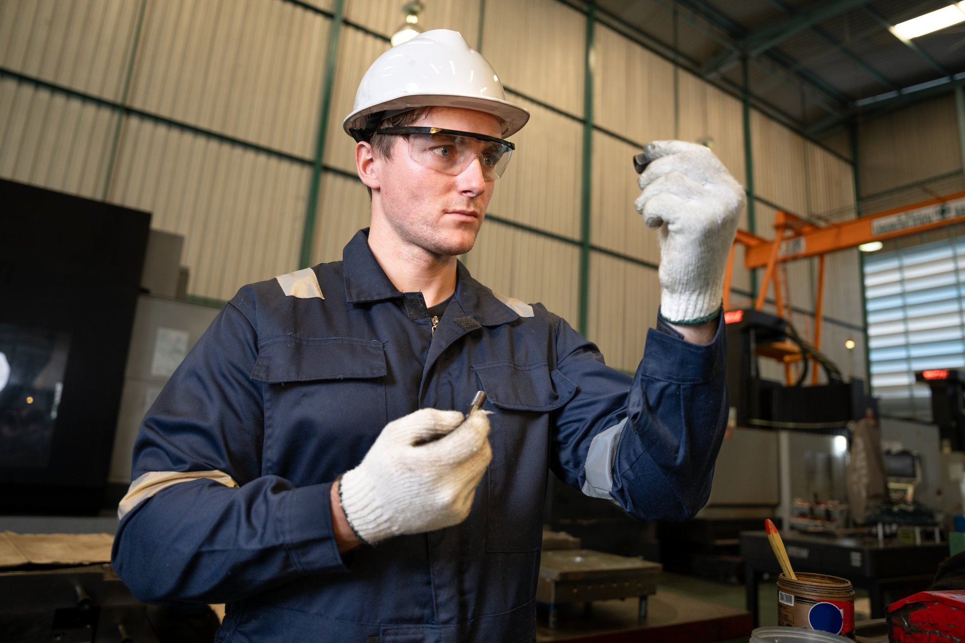 Engineer checking a component with a measuring tool in an industrial workshop