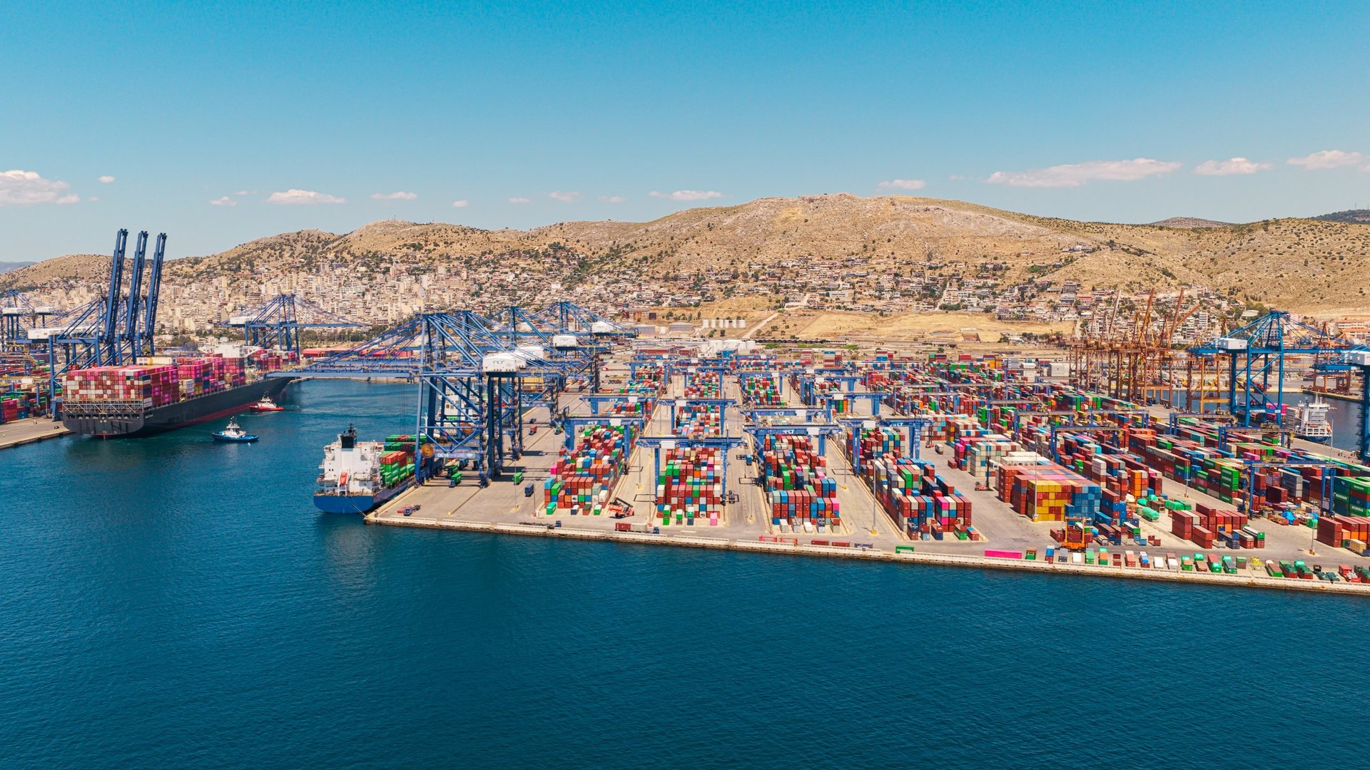 Port cargo terminal with cranes loading and unloading vessels at the boundary