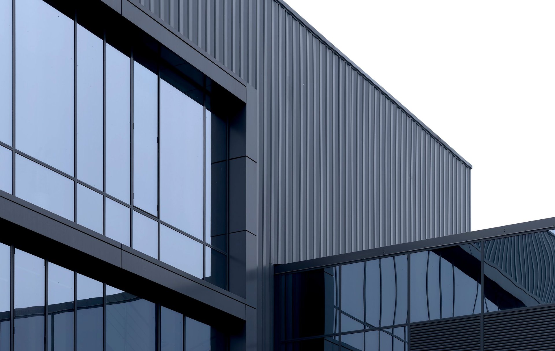 Modern building facade with corrugated metal cladding panels and glazing