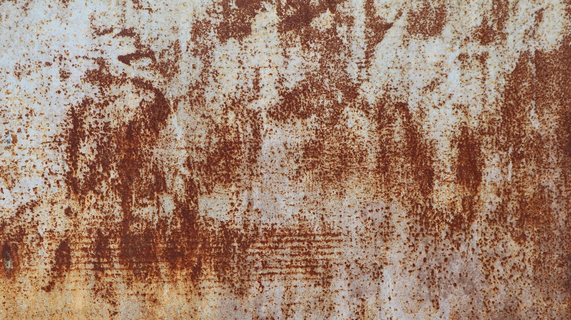 Close view of a corroded steel surface showing rust staining and pitting across the metal