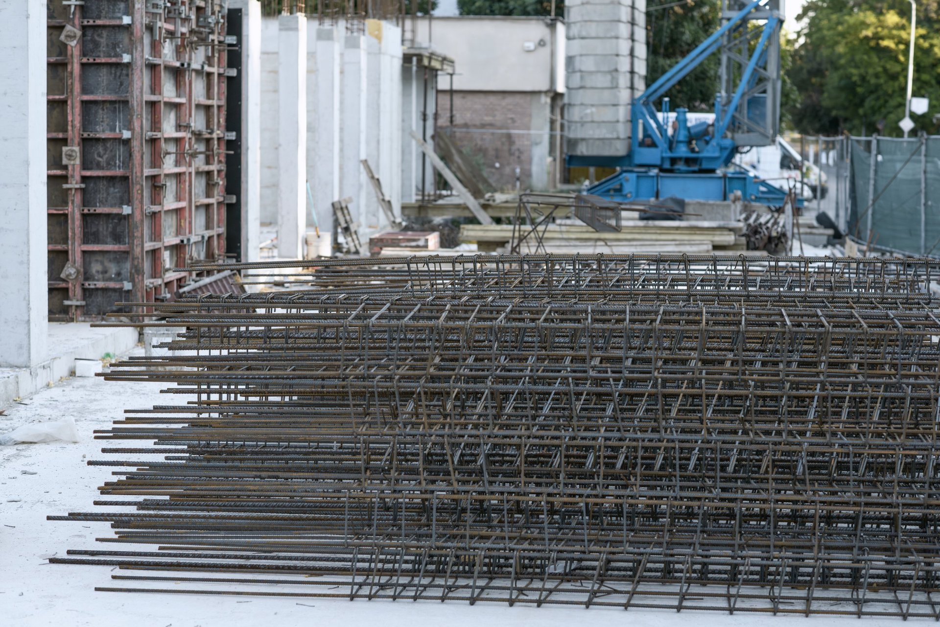 Foundation Rebar — stacked steel reinforcement cages and concrete formwork on an active site, showing bar-zone and lap/coupler context for foundation work.