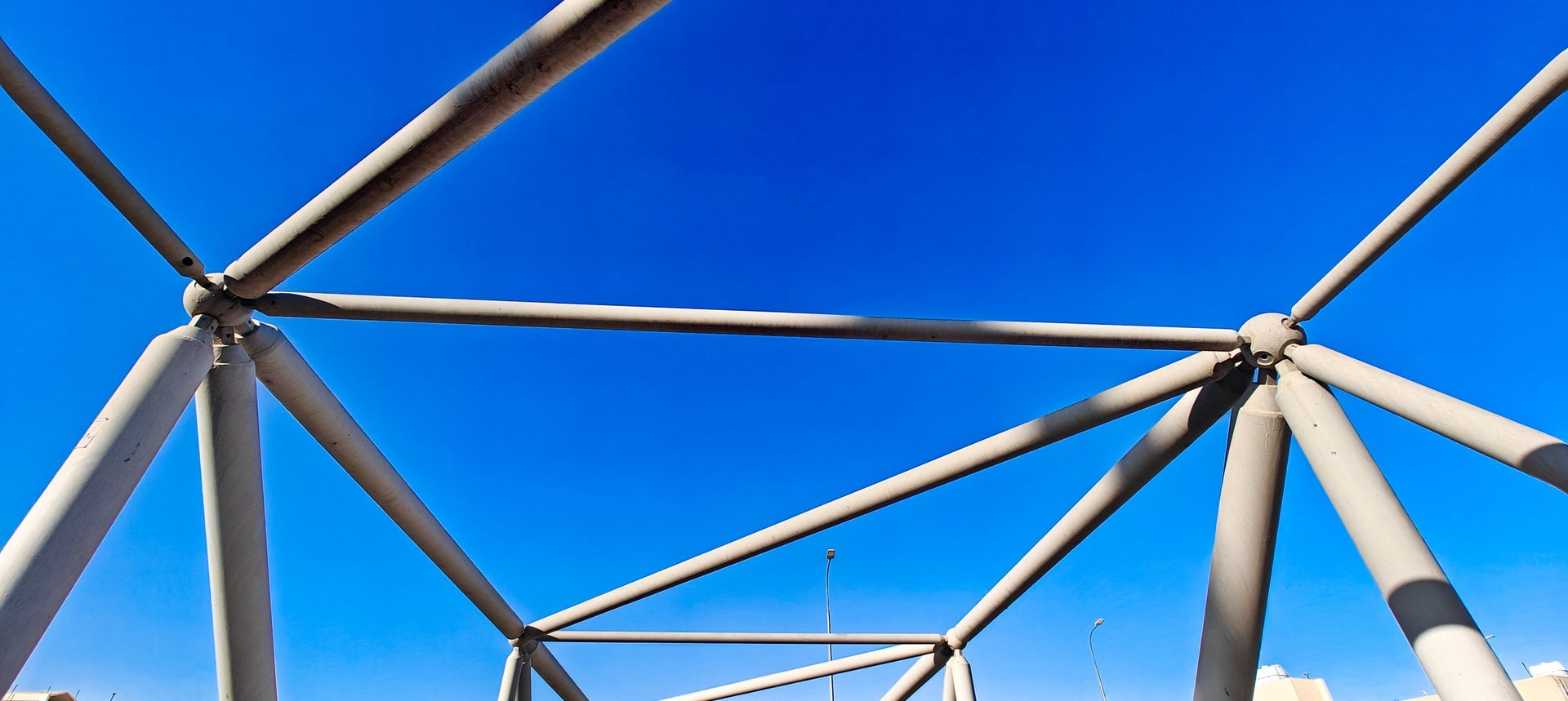 Structural steel truss spanning a road, representing higher-strength structural sheet work