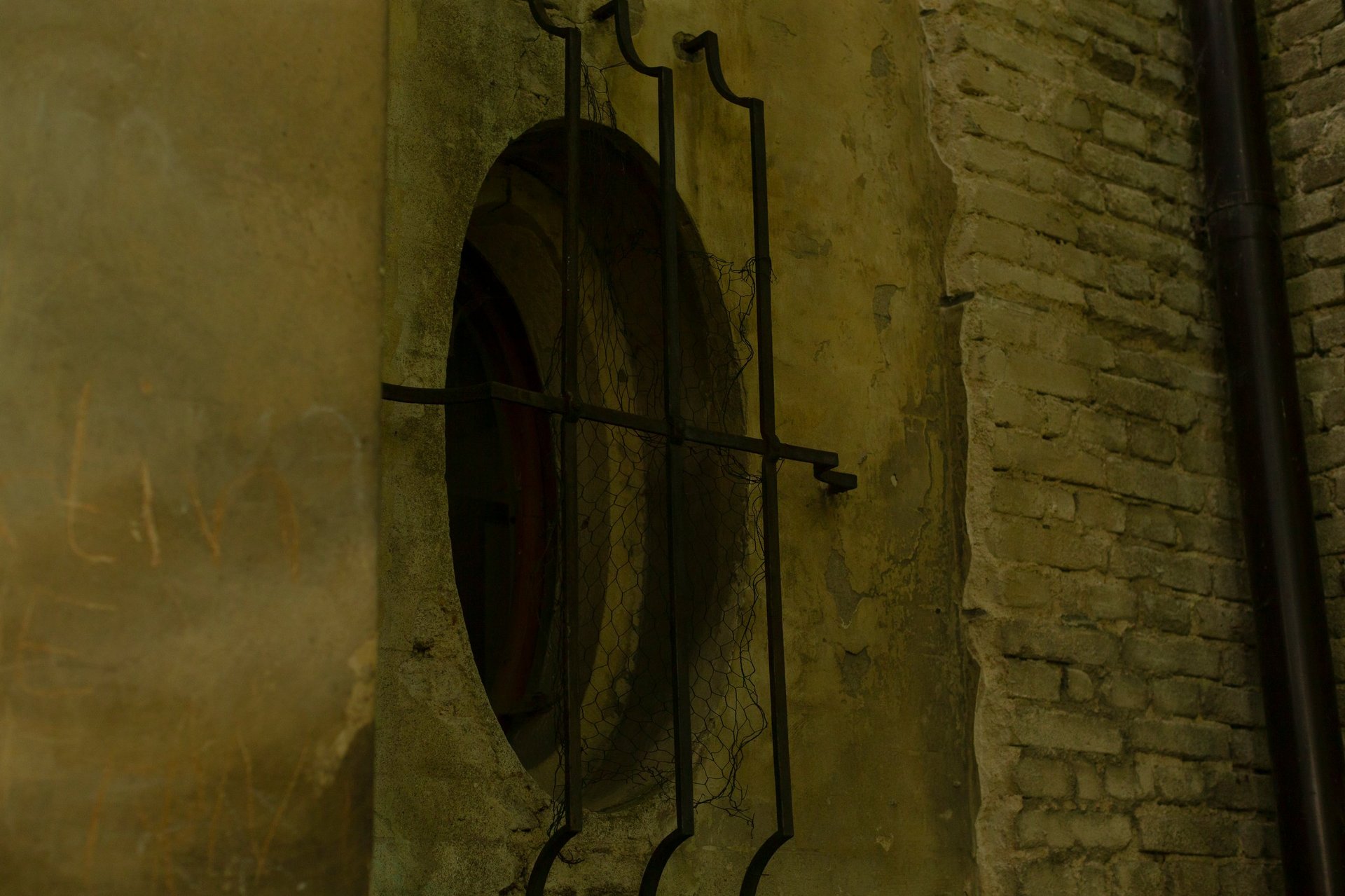 Elliptical window opening set into a brick wall, showing curved geometry