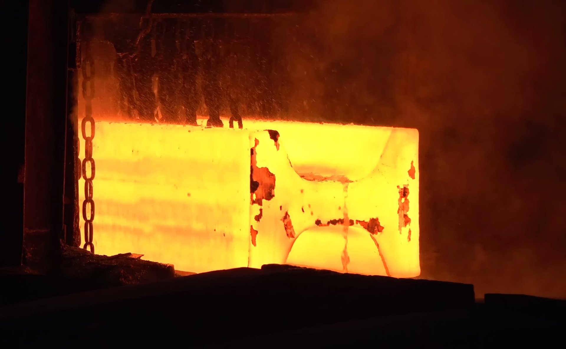 Molten metal pouring during steel production at a foundry, showing the raw material stage behind a grade specification