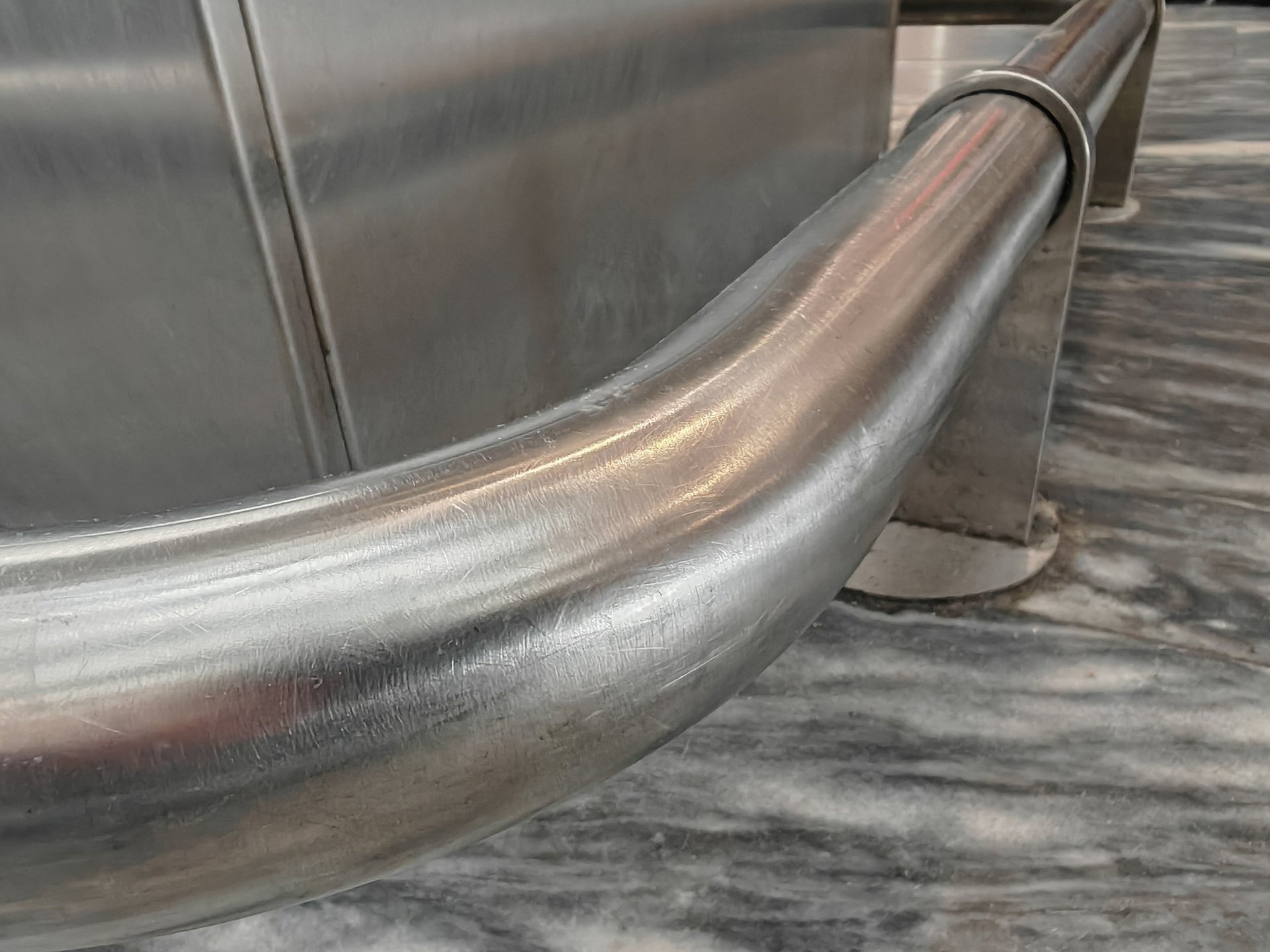 Close view of a stainless steel guard rail mounted at floor level