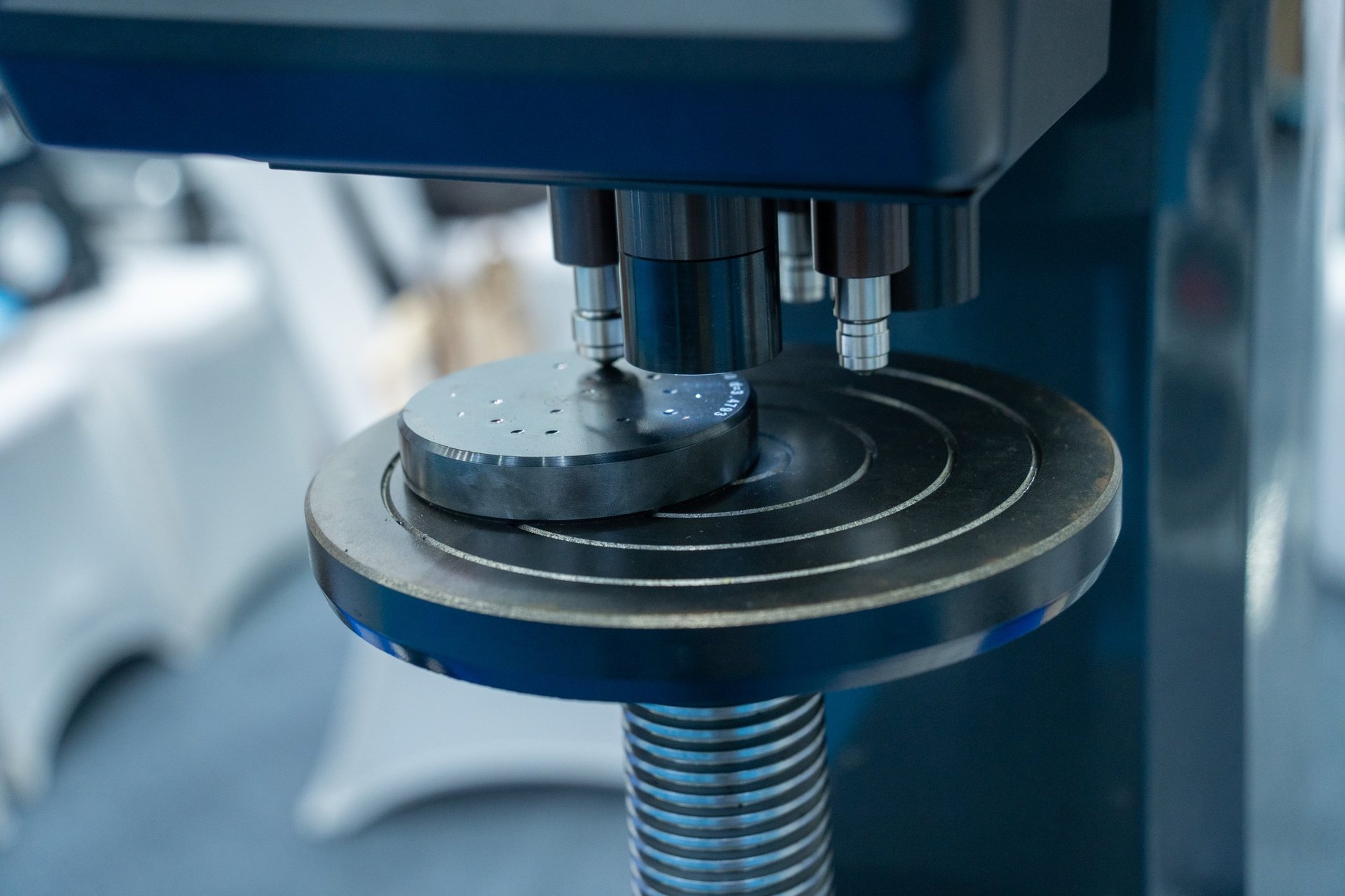 Hardness testing instrument checking a metal sample in a materials laboratory