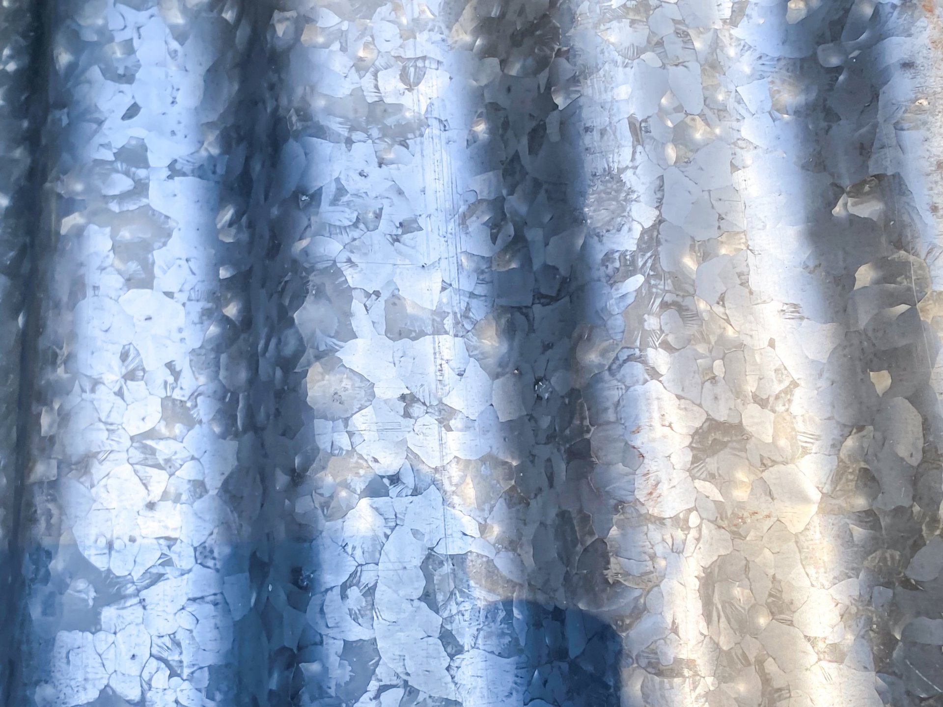 Corroded and cracked corrugated metal roofing sheets exposed to the weather