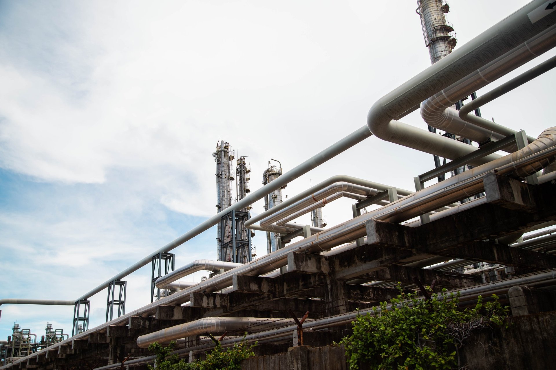 Petrochemical processing facility with an elevated alloy pipe rack